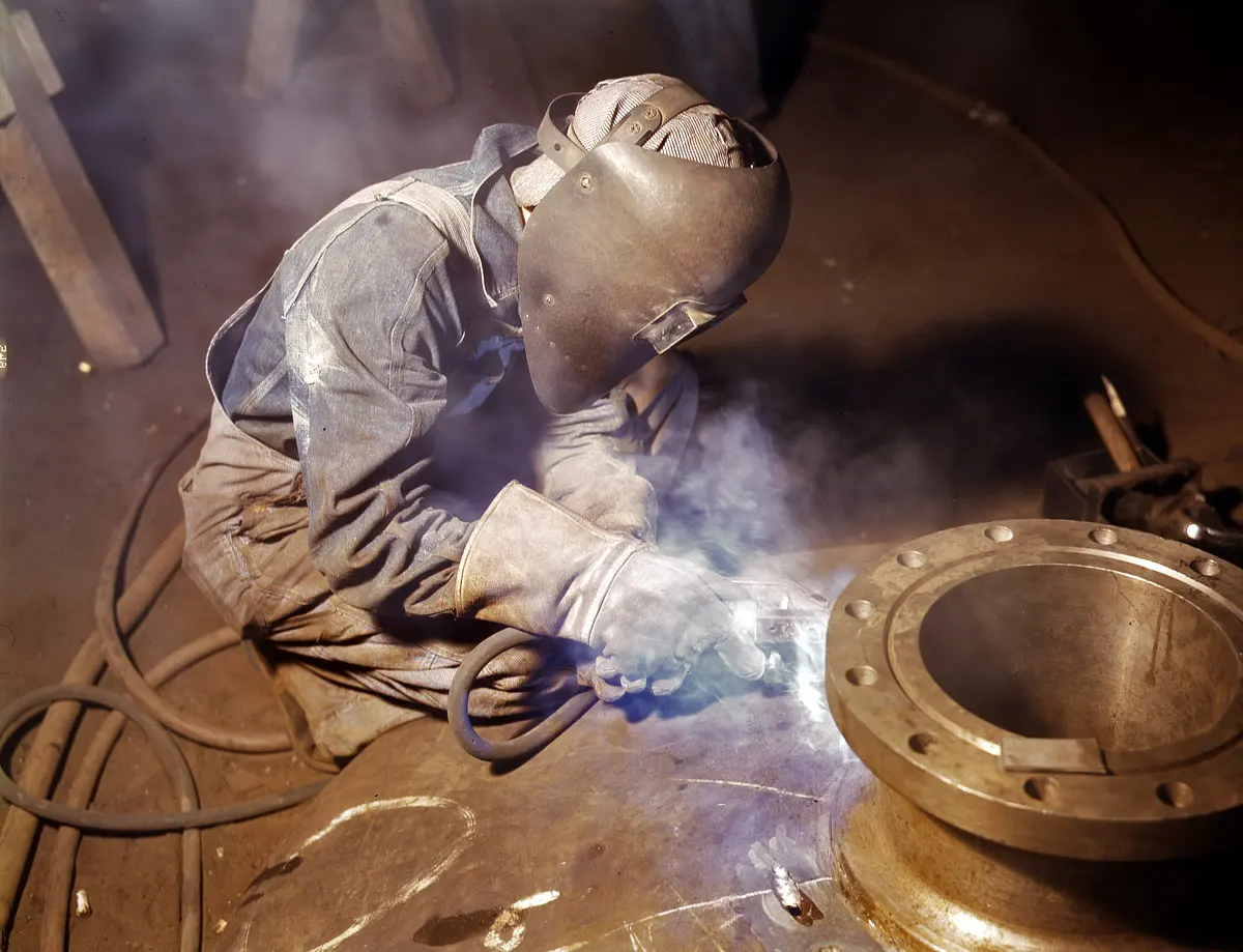 Chaudronnier en masque de soudage travaillant sur une bride